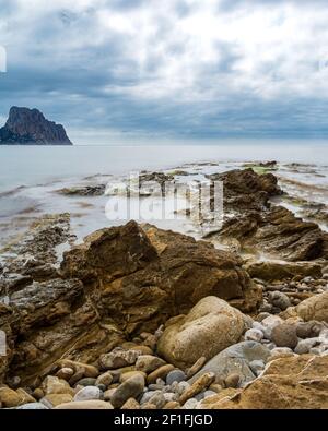 Las olas del mar lash line impactan la roca en la playa, situada en Alicante, Foto de stock