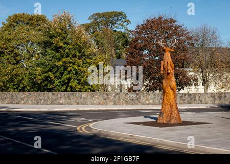 Tallado de madera de ciervo. Escultura de un ciervo rojo saltando al aire, tallado totalmente de un árbol muy antiguo existente en Killarney, Condado de Kerry, Irlanda. Foto de stock