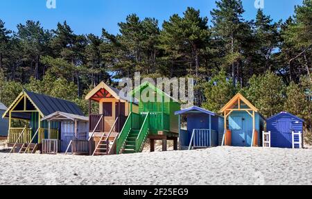 Algunas cabañas de playa de colores brillantes en Wells junto al mar Foto de stock