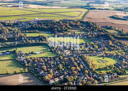 Una vista aérea de la aldea de Cotswold de Upper Rissington, Gloucestershire, Reino Unido - Little Rissington Airfield es visible en el fondo.