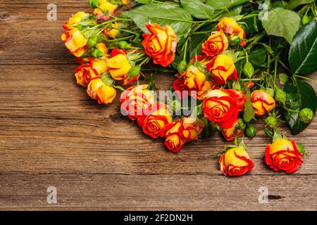 Ramo de rosas amarillo-anaranjadas brillantes en la vieja mesa de madera. Regalo festivo, tarjeta de felicitación para Semana Santa, Cumpleaños, día de San Valentín o Boda. Conceps. Vacaciones Foto de stock