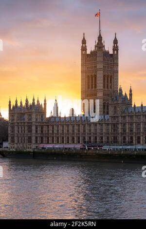 Hermosa puesta de sol sobre el Palacio de Westminster con el río Támesis en primer plano, visto desde el Puente de Westminster, Londres, diciembre de 2020