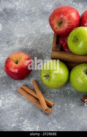 Manzanas verdes y rojas enteras deliciosas en caja de madera Foto de stock