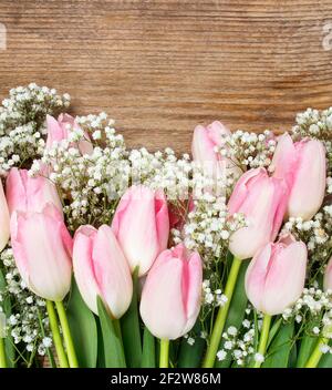 Hermosos tulipanes de color rosa y blanco sobre fondo de madera. Espacio de copia. Foto de stock