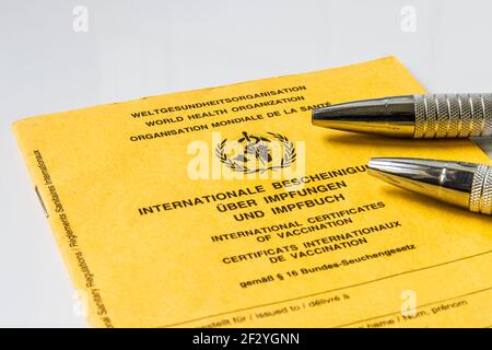 Certificado internacional de vacunación de la Organización Mundial de la Salud. Libro de vacunación amarillo con en tres idiomas con dos puntos de bola metálicos