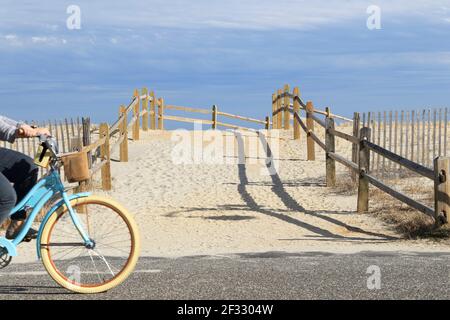 Sonrisa, estás en sea Isle es la frase de captura de sea Isle City, una ciudad costera en Nueva Jersey EE.UU. Un ciclista pasa por una rampa de acceso a la playa. Foto de stock