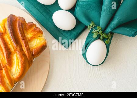 Pastel de levadura horneado con queso crema, huevos blancos de cerca sobre fondo blanco, plano con espacio para copias. Brioche francés tradicional y huevos Foto de stock