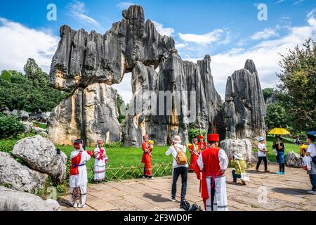 Kunming China , 4 de octubre de 2020 : turistas chinos con atuendo tradicional posando frente a la famosa pantalla de piedra en el bosque de piedra de Shilin Yunnan China Foto de stock