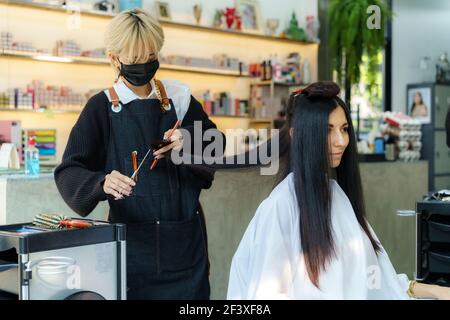 Estilista profesional mujer corte de pelo en la peluquería Foto de stock