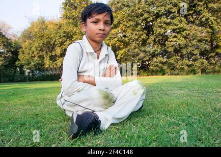 un niño sentado en el suelo durante un cricket