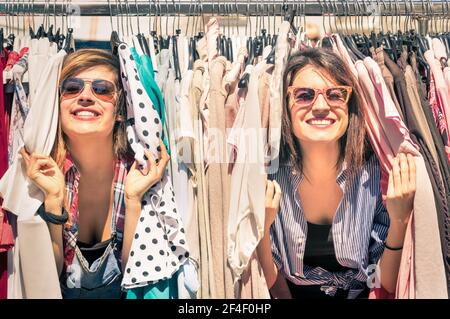 Jóvenes hermosas mujeres en el mercado semanal de telas - mejor amigos compartiendo tiempo libre divertirse y hacer compras en el casco antiguo en un día soleado Foto de stock