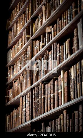 Biblioteca de época con estantes de libros antiguos en el Long Room en el Trinity College. Dublín, Irlanda - 15 de febrero de 2014