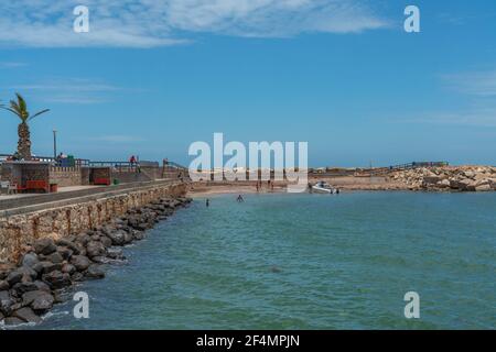 SWAKOPMUND, NAMIBIA - JAN 11, 2020: Playa pública con gente nadando en el océano en el paseo marítimo de Swakopmund. Namibia SWAKOPMUND, NAMIBIA - JAN 11, 2020: Playa pública con gente nadando en el océano en el paseo marítimo de Swakopmund. Namibia