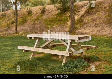 Mesa de picnic en un parque con zona verde Foto de stock