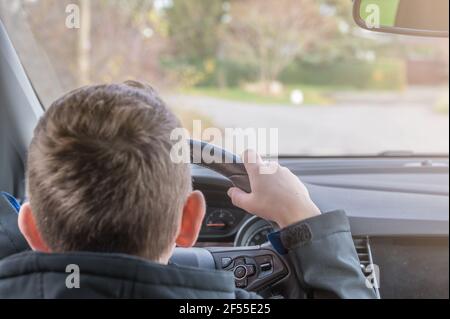 El niño descubre el mundo en el asiento del conductor de un coche Foto de stock