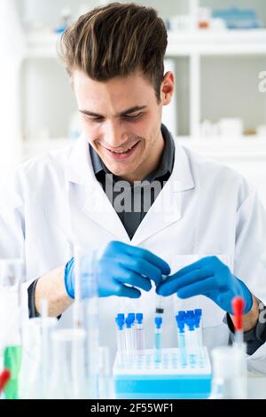 Sonriente hombre científico trabajando en el laboratorio
