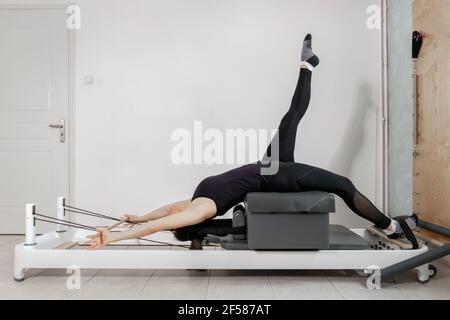 Una mujer haciendo ejercicios de pilates en una cama reformada