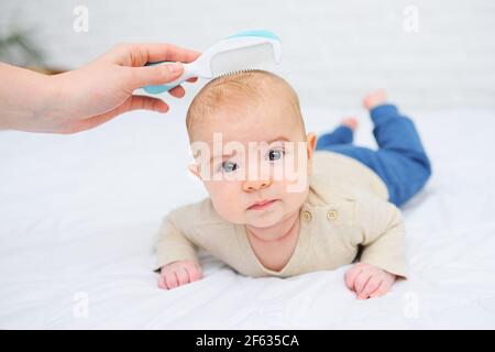 Mamá peine a un bebé recién nacido con un cepillo especial para el cabello.  Concepto de maternidad. Higiene del bebé Fotografía de stock - Alamy