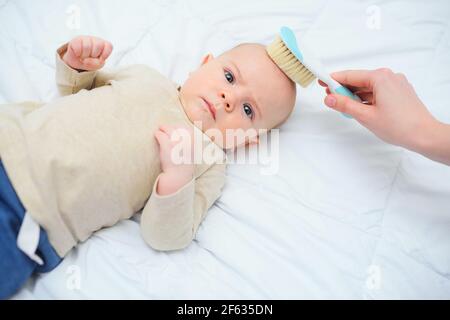 Mamá peine a un bebé recién nacido con un cepillo especial para el cabello.  Concepto de maternidad. Higiene del bebé Fotografía de stock - Alamy