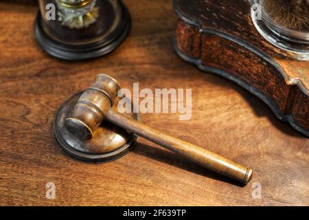 Los jueces pequeños de madera gavel en un escritorio en una visión de gran ángulo conceptual de la delincuencia, la ley y el orden, la sentencia, la corte o una subasta Foto de stock