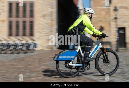 30 de marzo de 2021, Baja Sajonia, Osnabrück: Un oficial de policía monta un S-pedelec con equipos especiales de señalización como la luz azul y la sirena. En el área de Osnabrück, dos pedelecs de velocidad con equipo de señalización serán probados por los oficiales en los próximos doce meses, según la policía de Osnabrück. Las bicicletas eléctricas, que son de hasta 45 kilómetros por hora rápido, son para ayudar a la policía más amigable con los ciudadanos. Con las bicicletas, ya no hay una ventana obstructiva entre los oficiales y los ciudadanos, como es el caso de los coches de patrulla. Foto: Friso Gentsch/dpa Foto de stock