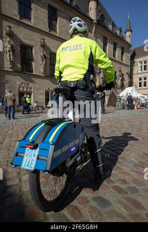 30 de marzo de 2021, Baja Sajonia, Osnabrück: Un oficial de policía está de pie sobre un S-pedelec con equipos especiales de señalización como la luz azul y la sirena. En el área de Osnabrück, dos pedelecs de velocidad con equipo de señalización serán probados por los oficiales en los próximos doce meses, según la policía de Osnabrück. Las bicicletas eléctricas, que son de hasta 45 kilómetros por hora rápido, son para ayudar a la policía más amigable con los ciudadanos. Con las bicicletas, ya no hay una ventana obstructiva entre los oficiales y los ciudadanos, como es el caso de los coches de patrulla. Foto: Friso Gentsch/dpa Foto de stock