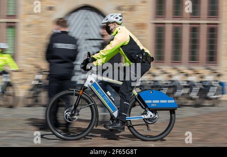 30 de marzo de 2021, Baja Sajonia, Osnabrück: Un oficial de policía monta un S-pedelec con equipos especiales de señalización como la luz azul y la sirena. En el área de Osnabrück, dos pedelecs de velocidad con equipo de señalización serán probados por los oficiales en los próximos doce meses, según la policía de Osnabrück. Las bicicletas eléctricas, que son de hasta 45 kilómetros por hora rápido, son para ayudar a la policía más amigable con los ciudadanos. Con las bicicletas, ya no hay una ventana obstructiva entre los oficiales y los ciudadanos, como es el caso de los coches de patrulla. Foto: Friso Gentsch/dpa Foto de stock