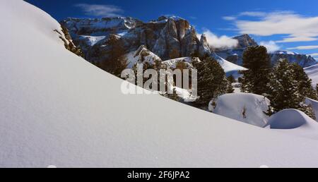 Schöne Wolken und Schnee an den Felsen des Sella Massiv bei Wolkenstein gegenüber vom Langkofel in Südtirol in den Dolomitas Italien Foto de stock