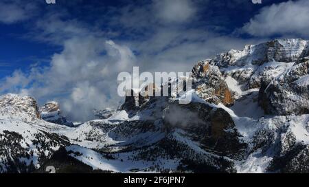 Dolomitas, schöne Wolken und Schnee an den Felsen des Sella Massiv bei Wolkenstein gegenüber Langkofel in Südtirol in den Dolomitas Italien Foto de stock
