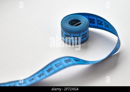 Cinta de medición azul de sastre aislada sobre fondo blanco. Foto de stock