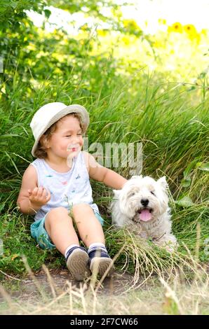 niño y perro sentados en la hierba Foto de stock
