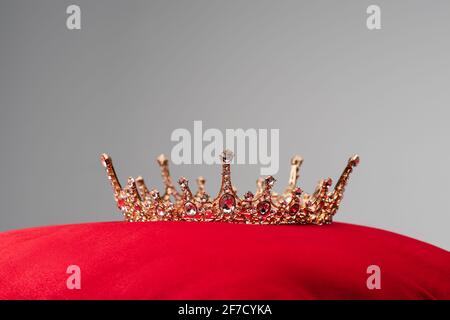 corona real sobre cojín de terciopelo rojo aislado en gris Foto de stock