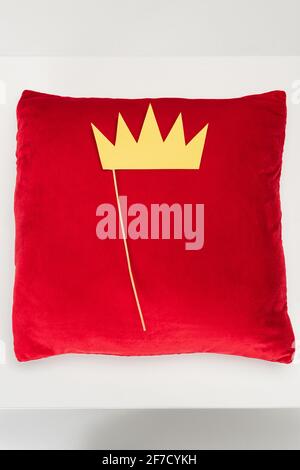 vista superior de la corona de papel en el palo y terciopelo rojo almohada en gris Foto de stock
