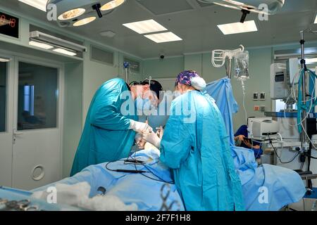 los médicos trabajan duro en el quirófano Foto de stock