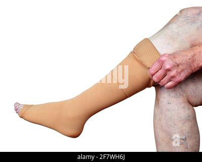 Medias de trombosis en una pierna de mujer mayor aisladas sobre fondo blanco. Foto de stock
