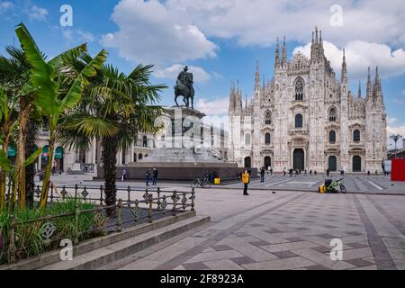 Milán, Italia. 10th de abril de 2021. Piazza del Duomo (Plaza de la Catedral), Milán y las palmeras verdes en frente de la catedral, detrás del monume ecuestre Foto de stock
