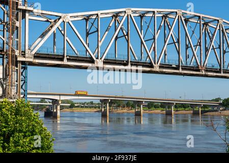 Cruce el puente sobre el río Arkansas en Little Rock, Arkansas, Estados Unidos. En la distancia, tranvía amarillo cruzando el río. Foto de stock