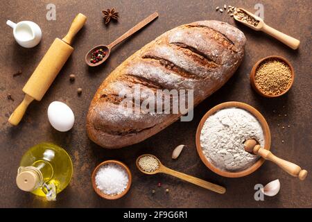 Pan recién hecho e ingredientes de panadería para hornear pan casero en la mesa. Receta de alimentos vista superior en la textura de fondo de piedra con espacio de copia. Plana