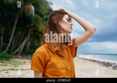 la mujer en una solda con el pelo suelto está descansando encendido una isla cerca del mar y palmeras en el antecedentes Foto de stock