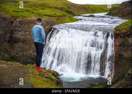 Caminante en el borde de la cascada de Thufoss Reykjavik en Islandia Foto de stock