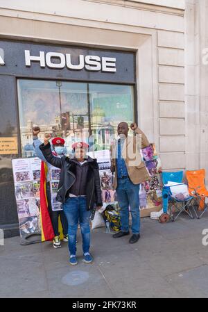 Un trío de manifestantes pro democracia y derechos humanos fuera de Uganda House, oficina de la Alta Comisión de Uganda, Trafalgar Square, Londres, Inglaterra, Reino Unido Foto de stock