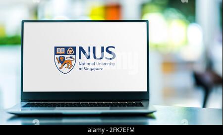 POZNAN, POL - 20 DE ABRIL de 2021: Ordenador portátil con logotipo de la Universidad Nacional de Singapur (NUS), la universidad nacional de investigación de Singapur Foto de stock