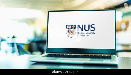 POZNAN, POL - 20 DE ABRIL de 2021: Ordenador portátil con logotipo de la Universidad Nacional de Singapur (NUS), la universidad nacional de investigación de Singapur Foto de stock