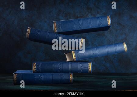 Libros antiguos, flotando sobre un fondo azul Foto de stock