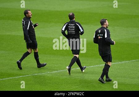 El árbitro Paul Tierney (centro) y sus asistentes llevan una camiseta 'cruce la línea, refspect' durante el calentamiento antes del partido de la Premier League en los Hawthorns, West Bromwich. Fecha de emisión: Lunes 3 de mayo de 2021. Foto de stock