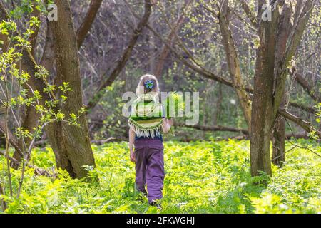 Adorable niña de senderismo en el bosque en una primavera día Foto de stock