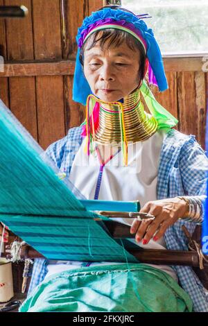 INLE, MYANMAR - 28 DE NOVIEMBRE de 2016: La mujer de cuello largo Kayan está tejiendo una tela en un taller en el lago Inle, Myanmar
