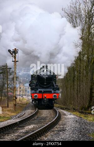 Histórico tren de vapor (loco) puffing nubes de humo, viajar en el ferrocarril patrimonio escénico (señal, la gente a bordo) - KWVR, Yorkshire, Inglaterra, Reino Unido. Foto de stock