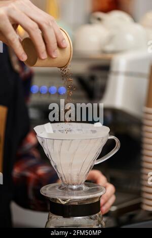 manos masculinas vertiendo café molido en el filtro Fotografía de stock -  Alamy