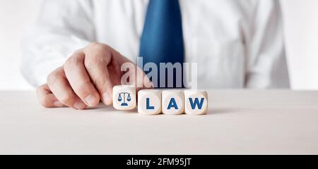 Hombre de negocios colocando los cubos de madera con la palabra ley. Concepto de legislación empresarial o de normas jurídicas.